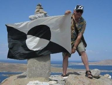 Joe Cardella holding the ARTLIFE flag at one of his travel locations